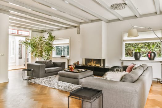 a living room with two couches, a coffee table and a fireplace in the center of the room is surrounded by white walls