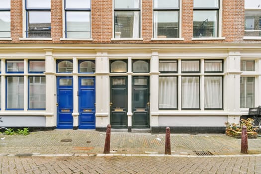 a brick building with blue door and window panes on the outside, in front of a bicycle parked next to it