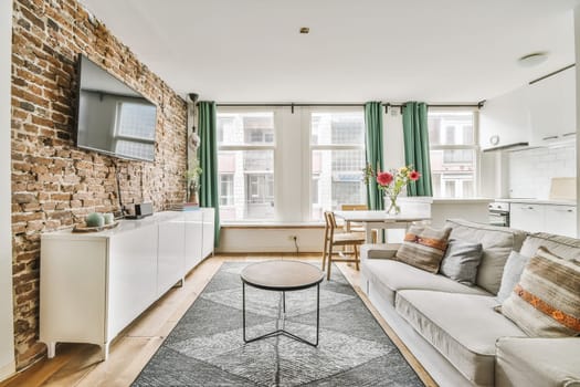 a living room with exposed brick walls and an area rug that has been used as a carpet for the floor