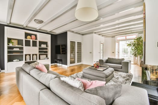 a living room with couches and a television set in the center of the room on the right is a fireplace