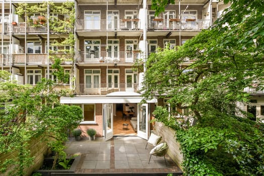 an apartment building with lots of plants and trees in the fore - image is taken from above, looking down