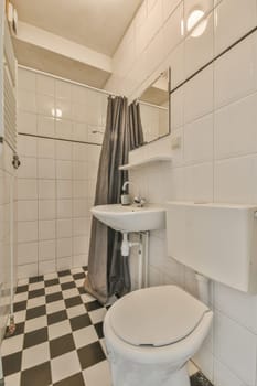 a bathroom with black and white checkered tiles on the floor, sink, toilet, and shower in it