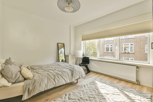 a bedroom with white walls and wood flooring in the middle of the room, there is a large window that looks out into