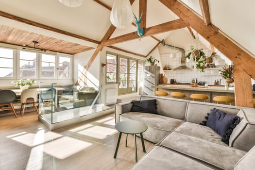 a living room with couches, tables and an open kitchen area in the corner of the room is shown