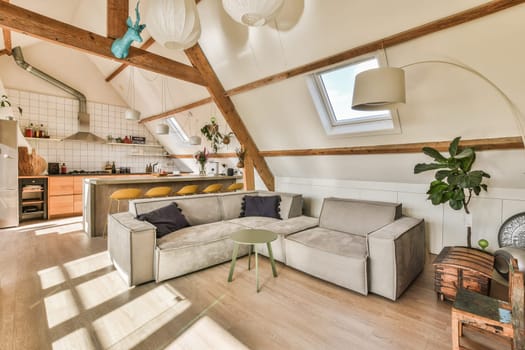 a kitchen and living room in an attic style home with white walls, hardwood flooring and exposed ceilings
