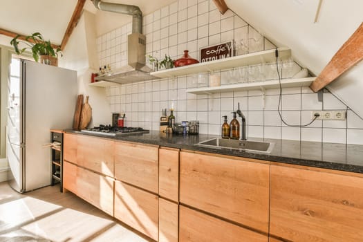 a kitchen with wooden cabinets and black counter tops in the center of the room is an open door that leads to a small patio