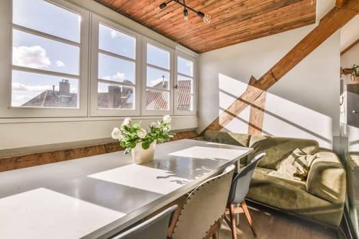 a dining room with wooden ceiling and white table in the corner, looking out to the city from the window