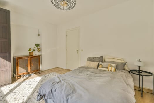 a bedroom with a bed, dresser and mirror on the wall in front of the room is very white color