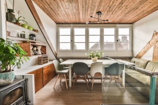 a kitchen and dining area in a house with wood floors, white walls, wooden ceiling, and green chairs