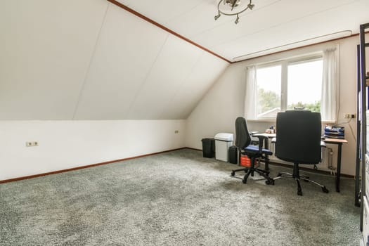 an empty room with a desk and computer on the floor in front of a window that looks out onto the street