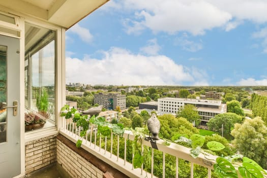 a balcony with trees and buildings in the background, as seen from an apartment window looking out onto the street