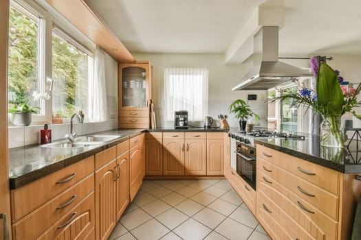 a kitchen with wood cabinets and marble counter tops, in the center of the room is a large window that looks out onto the