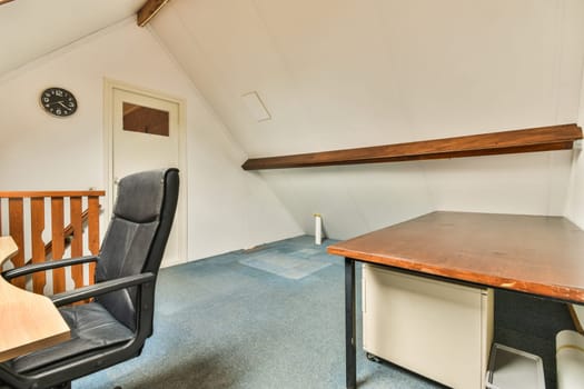 an office space with a desk, chair and clock on the wall in the corner of the room is empty