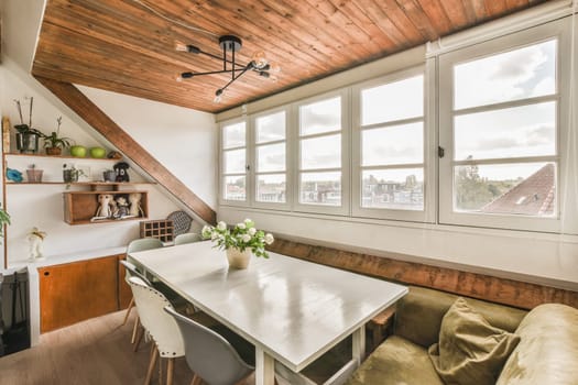 a kitchen and dining area in a house with wooden ceilings, white walls and wood flooring on the ceiling