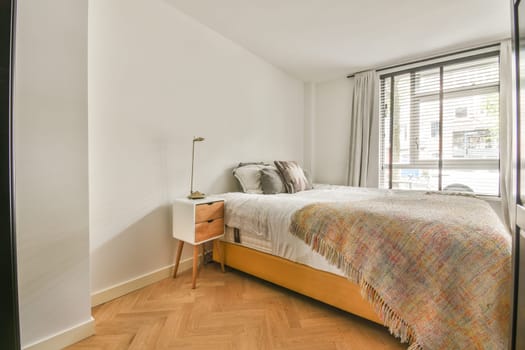 a bedroom with wood flooring and white walls, including a bed in the fore - image taken from above