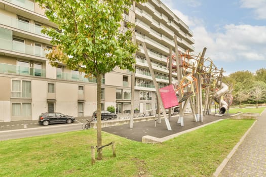 an apartment building with a playground in the front and cars parked on the street next to it, as well