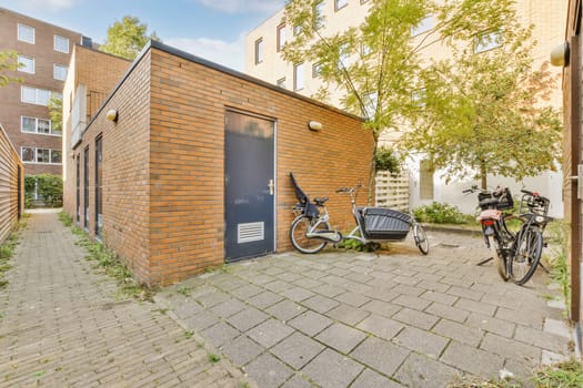 a bike parked in front of a brick building with a bicycle leaning against the wall on the side of the building