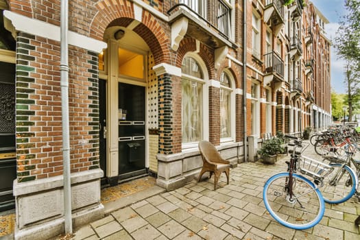a bicycle parked in front of a brick building on a sidewalk with two bikes leaning against each other buildings behind it