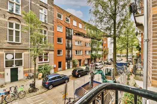 an urban street with parked cars and bicycles in amsterdam, the netherlands - stockfoorenlimm com