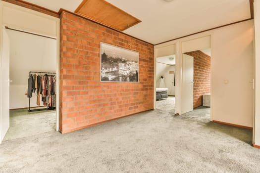 a red brick wall hanging on the side of a white door in a room with carpeted floor and walls