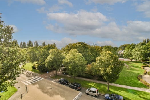 a parking area with cars parked in the lot and trees on either side of the road, as seen from above