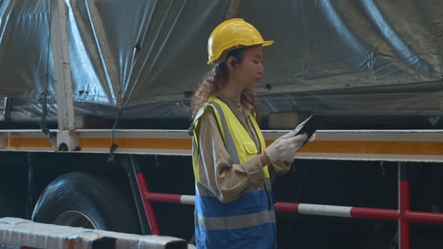 Industrial woman curly hair engineer wear safety uniform with hardhat checking metal sheet on cargo truck before shipment to customer in warehouse store factory workshop, logistics and transportation