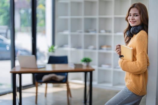 happy young woman with headphones is immersed in a book, happily learning.