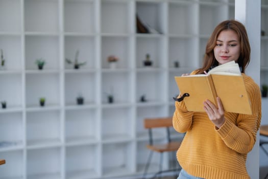 happy young woman with headphones is immersed in a book, happily learning.
