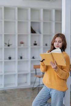 happy young woman with headphones is immersed in a book, happily learning.