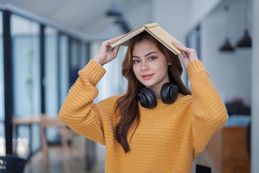 happy young woman with headphones is immersed in a book, happily learning.