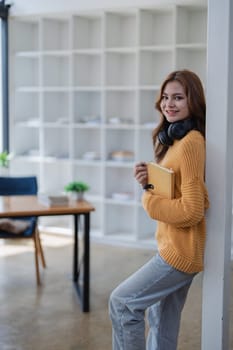 happy young woman with headphones is immersed in a book, happily learning.
