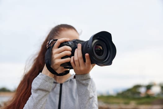 A young woman capturing stunning nature images with a DSLR camera, demonstrating her enthusiasm for photography in a serene outdoor setting
