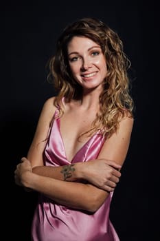 Beautiful slender woman in pink silk dress smiling