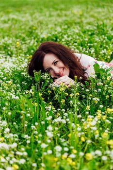woman lying in a field with flowers in spring and smiling