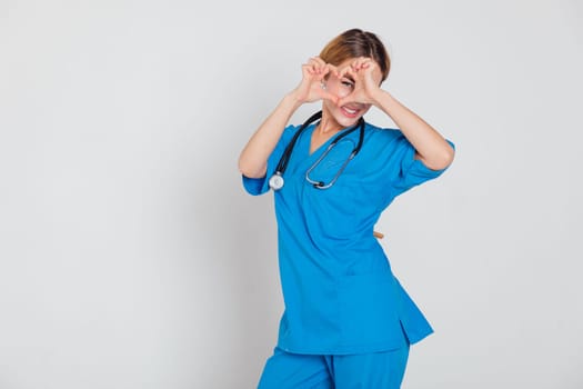Beautiful Woman Doctor With Stethoscope In Hospital Showing Hand Heart