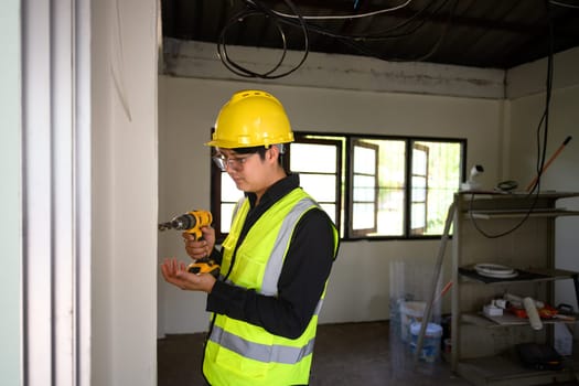 Construction worker using a drill during renovation work.