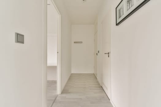 A spacious and bright corridor featuring a minimalist design, characterized by clean lines and neutral colors that create an inviting atmosphere.