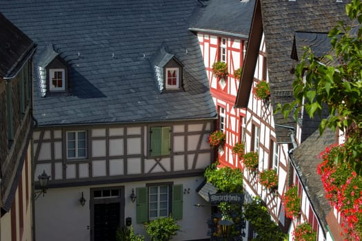 BEILSTEIN, GERMANY - SEPTEMBER 03 2022: historic village along the river Moselle with old half-timbered houses and the ruins of castle Metternich on top of the hills