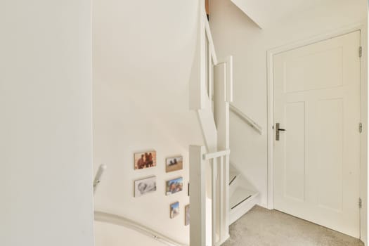 A bright and modern interior featuring a staircase adorned with wall art. The clean lines and neutral colors create an inviting atmosphere.