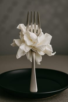 White flower with fork on black background, AI generation.