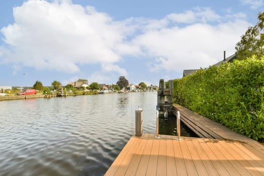 A peaceful view of a waterway lined with greenery and a wooden dock, showcasing a tranquil setting for relaxation and nature enjoyment.