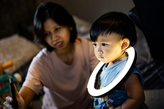 Mom And Toddler Plays With A Ring Light On His Neck, Background for advertising and wallpaper in relaxion and lifestyle scene.