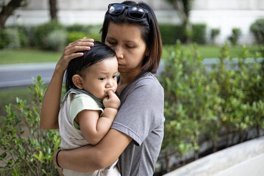 Mother Carries Her Child While Enjoying In The Garden, Background for advertising and wallpaper in summer and lifestyle scene.