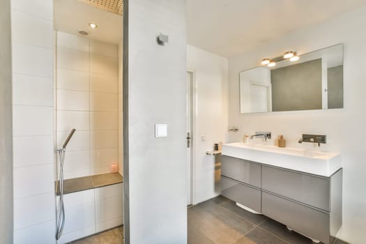 Contemporary bathroom featuring a sleek shower area and stylish vanity, complemented by elegant lighting and minimalistic decor for a serene atmosphere.