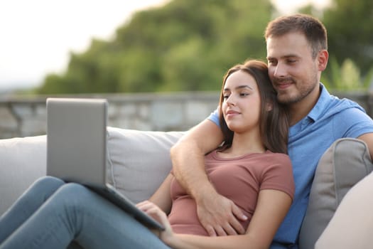 Couple checking laptop in a terrace