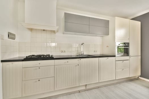Spacious and sleek kitchen featuring white cabinetry, black countertops, and modern appliances, creating an inviting culinary space.