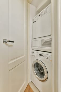 A neatly organized laundry area featuring a stacked washer and dryer tucked away in a built-in closet. The clean lines and bright color create a functional space.
