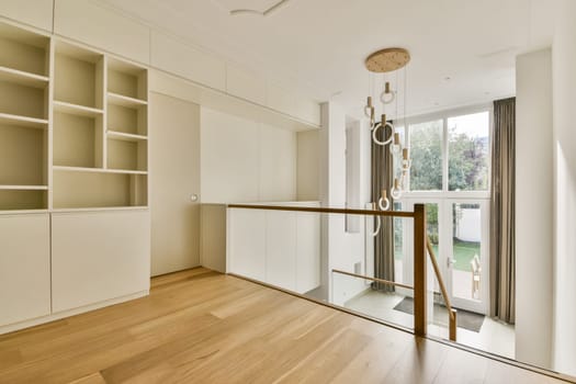 Bright and spacious interior featuring wooden flooring, stylish shelving, and large windows that allow natural light to illuminate the environment.