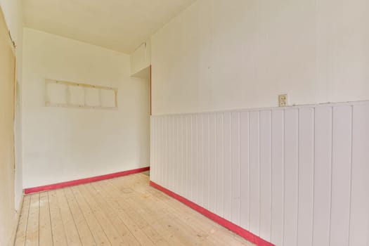 A bright and airy interior featuring wooden flooring and white walls, complemented by a touch of vibrant red trim, creating a minimalist aesthetic.