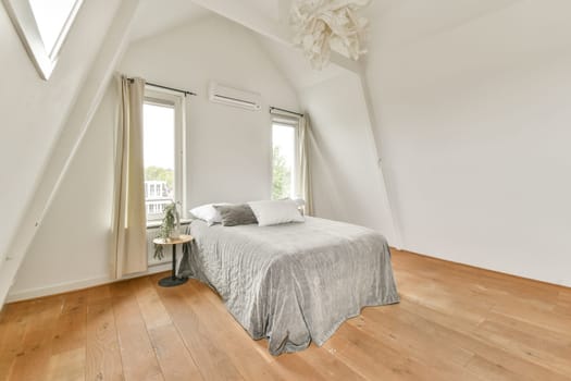 Bright and spacious minimalist bedroom design featuring a cozy bed, natural light, and wooden flooring that creates a serene atmosphere.